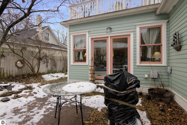 snow covered patio with fence and area for grilling