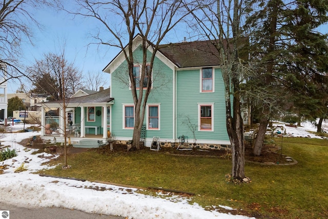 victorian-style house with covered porch and a yard