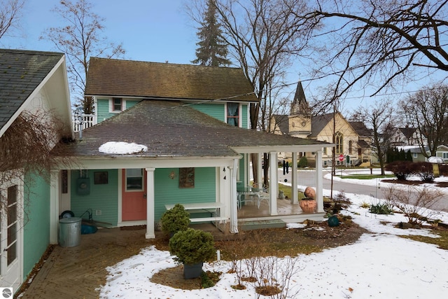 view of front of home with roof with shingles and covered porch