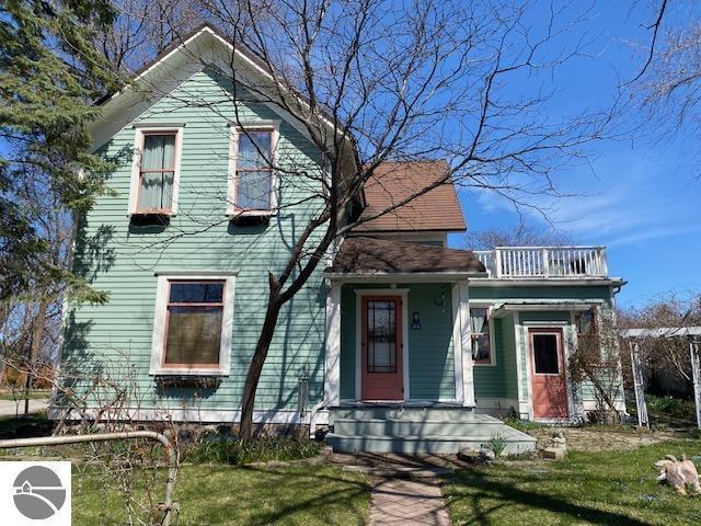 victorian home with a balcony and a front yard