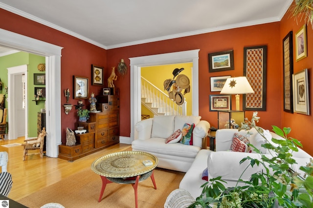 living area with baseboards, wood finished floors, stairs, and crown molding