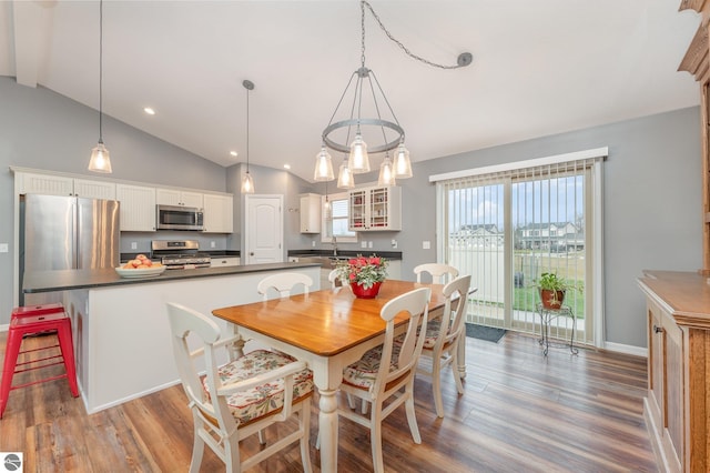 dining area with hardwood / wood-style floors and vaulted ceiling