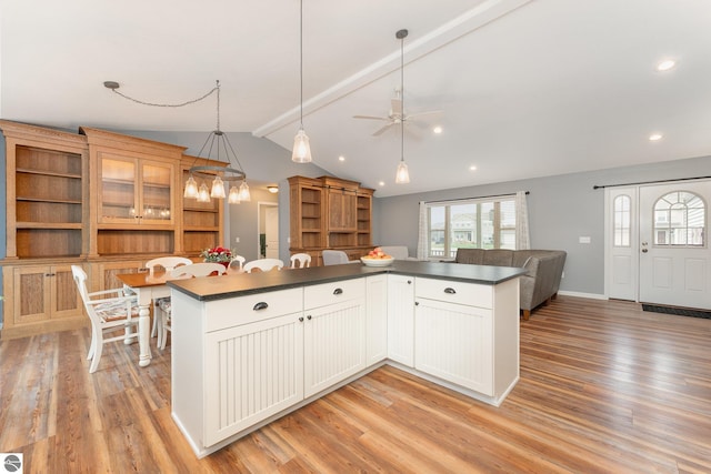 kitchen featuring white cabinets, lofted ceiling with beams, ceiling fan, light wood-type flooring, and decorative light fixtures