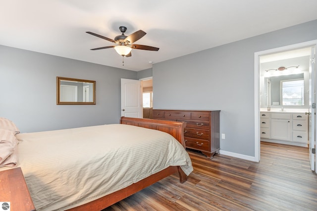 bedroom with ensuite bathroom, ceiling fan, dark hardwood / wood-style flooring, and multiple windows