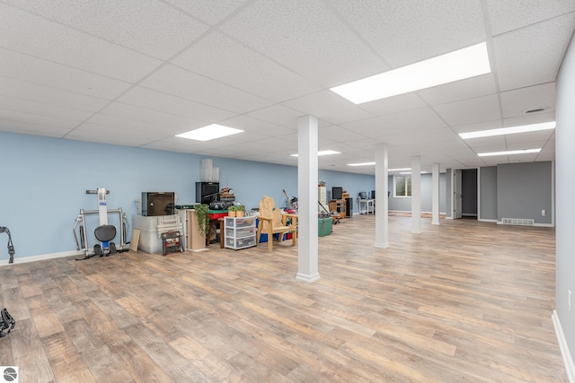 basement with a drop ceiling and wood-type flooring