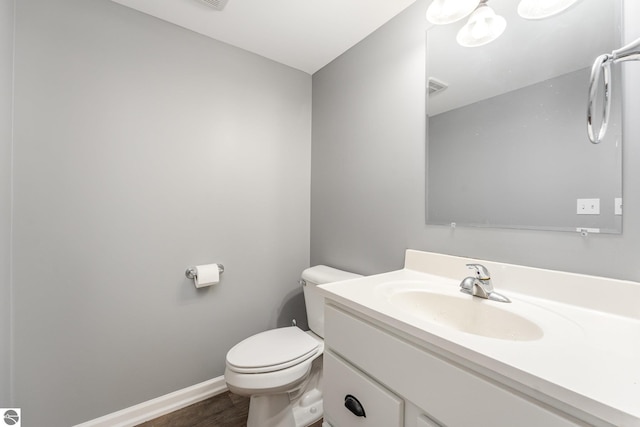 bathroom with vanity, wood-type flooring, and toilet