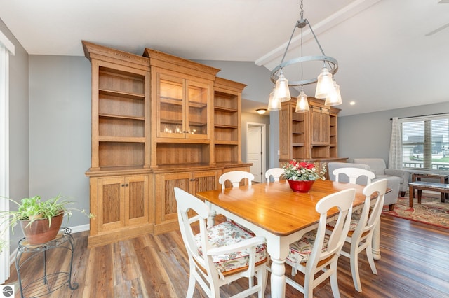 dining space with dark hardwood / wood-style flooring and lofted ceiling with beams