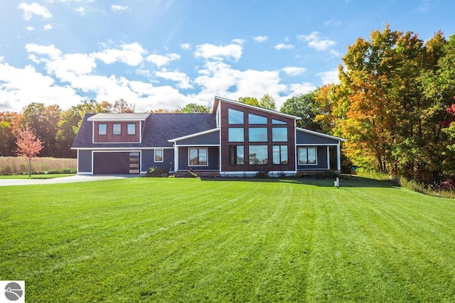 rear view of house with a garage and a lawn