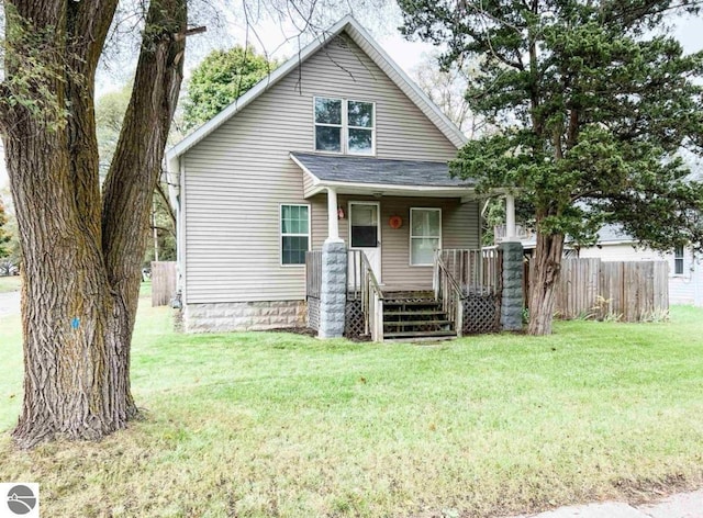 bungalow-style house featuring covered porch and a front yard