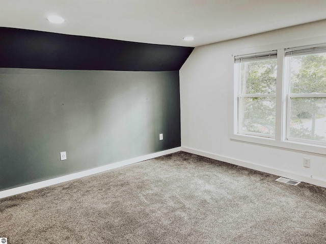 additional living space featuring carpet flooring and vaulted ceiling