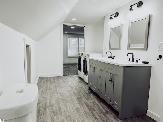 bathroom with washing machine and dryer, vanity, lofted ceiling, and hardwood / wood-style flooring