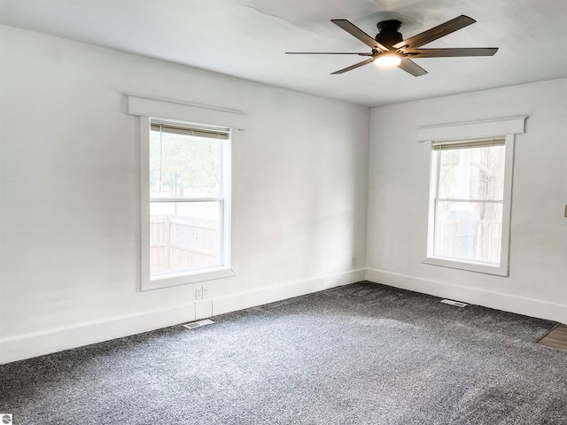 carpeted empty room featuring ceiling fan and plenty of natural light