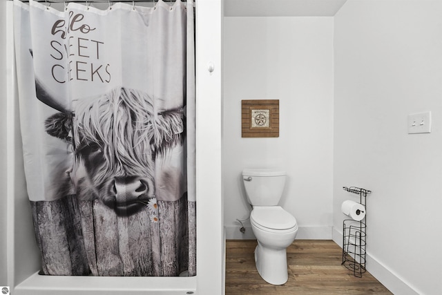 bathroom featuring a shower with shower curtain, wood-type flooring, and toilet