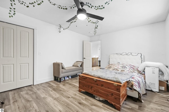 bedroom featuring ceiling fan, light wood-type flooring, and a closet