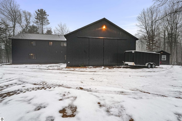 snow covered property featuring an outbuilding