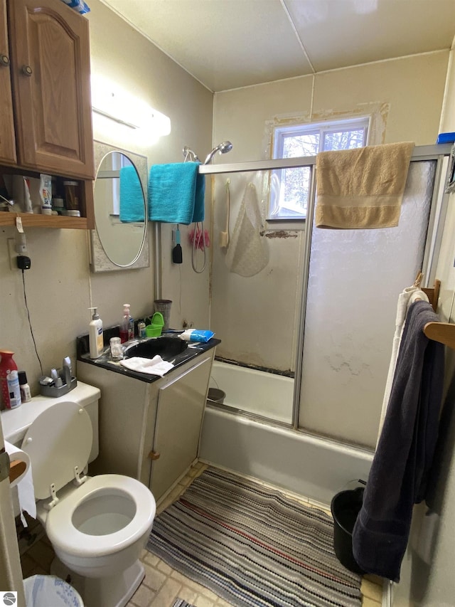 full bathroom featuring vanity, enclosed tub / shower combo, and toilet