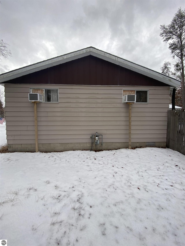 view of snow covered back of property