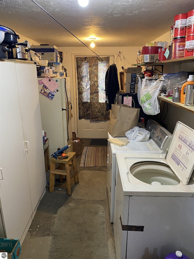 clothes washing area featuring washer and dryer and a textured ceiling