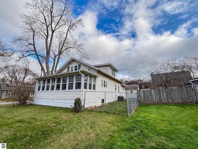 view of home's exterior featuring a sunroom and a lawn