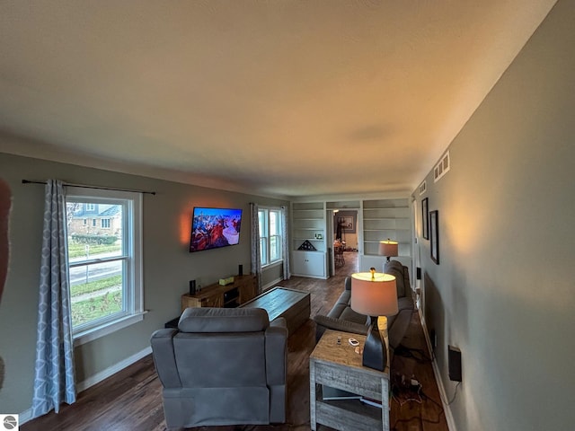 living room with wood-type flooring and built in features