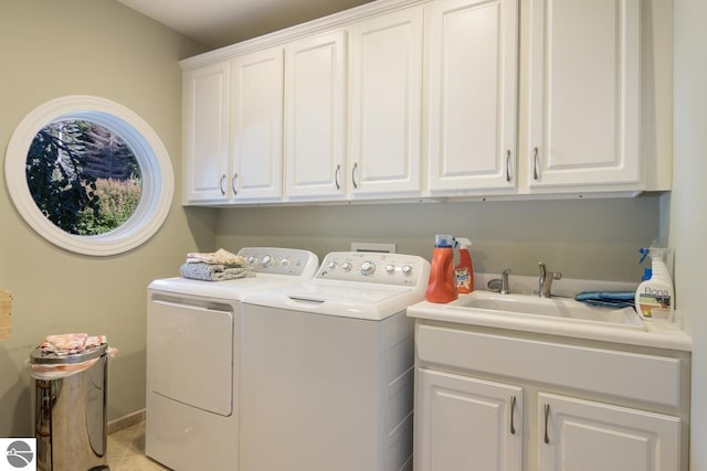 clothes washing area with cabinets, independent washer and dryer, light tile patterned floors, and sink