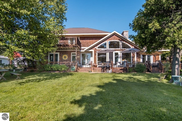 back of property featuring a lawn and a balcony