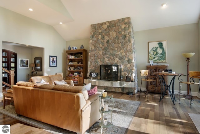 living room with a fireplace, dark wood-type flooring, and vaulted ceiling