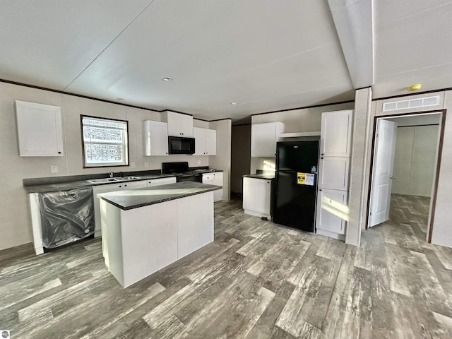 kitchen with black appliances, a center island, wood-type flooring, white cabinetry, and sink