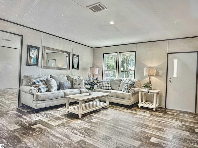 living room with hardwood / wood-style flooring and crown molding