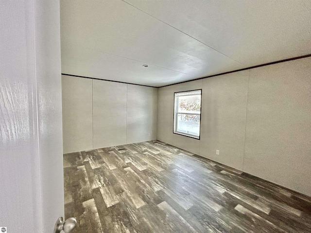 empty room with hardwood / wood-style floors and ornamental molding