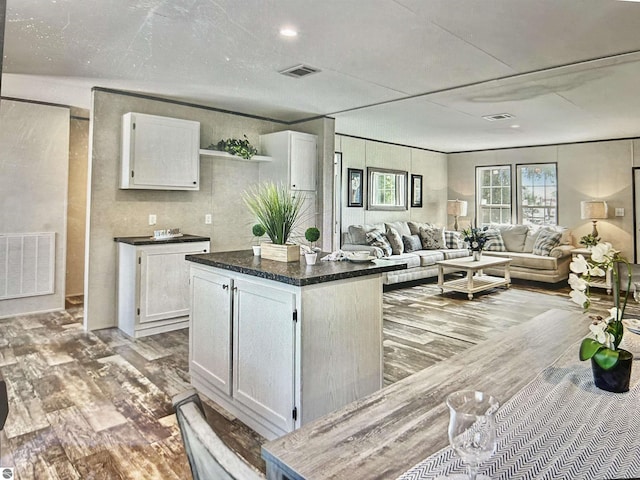 kitchen with hardwood / wood-style floors, white cabinetry, and a center island