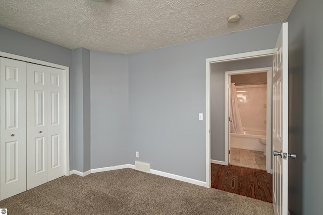 unfurnished bedroom featuring a closet, carpet floors, and a textured ceiling