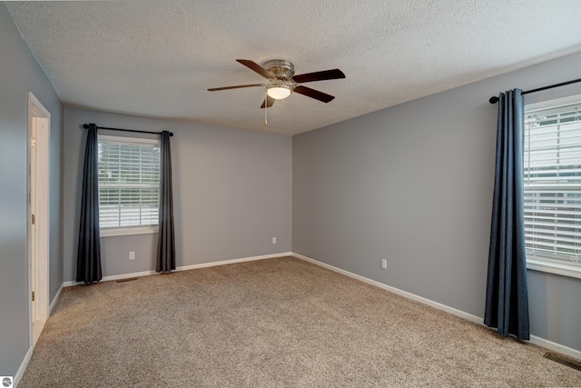 carpeted empty room with ceiling fan and a textured ceiling