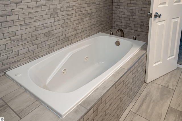 bathroom featuring tile patterned floors and tiled tub