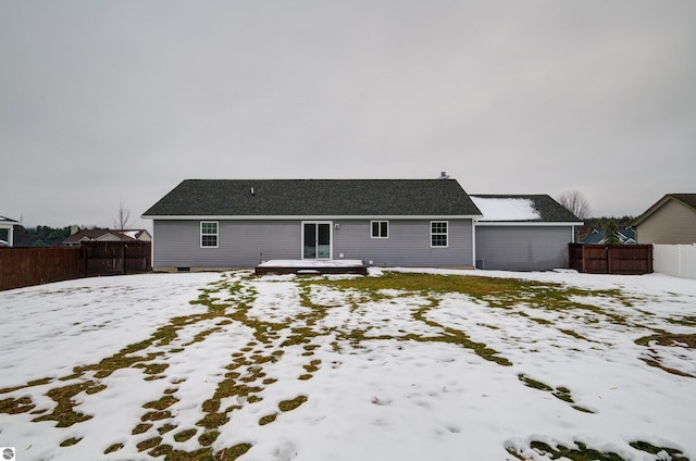 view of snow covered back of property