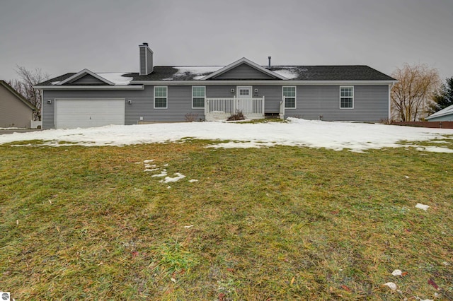 back of property with a yard and a garage