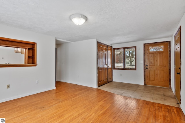 foyer with light hardwood / wood-style floors and a textured ceiling