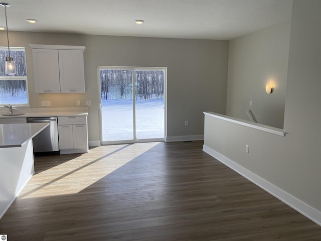 kitchen with stainless steel dishwasher, decorative light fixtures, white cabinets, and dark wood-type flooring