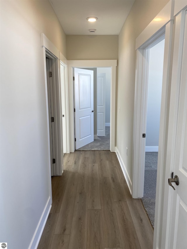 hallway with hardwood / wood-style flooring