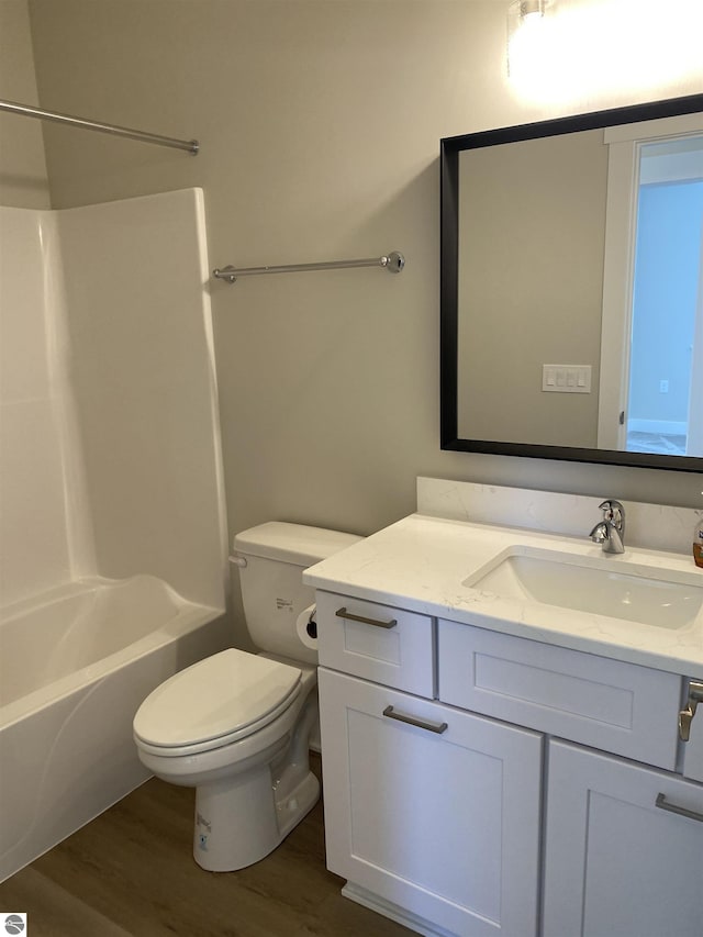 full bathroom with bathing tub / shower combination, toilet, vanity, and hardwood / wood-style flooring