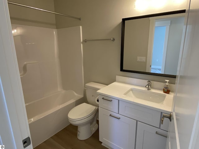 full bathroom with hardwood / wood-style floors, vanity, toilet, and tub / shower combination