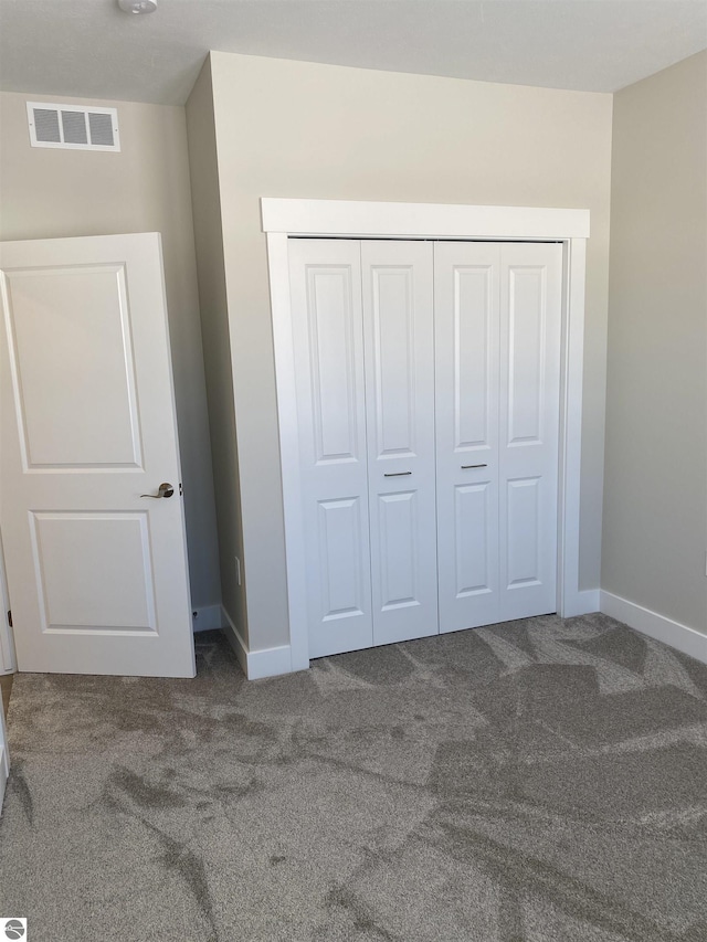 unfurnished bedroom with carpet flooring and a closet