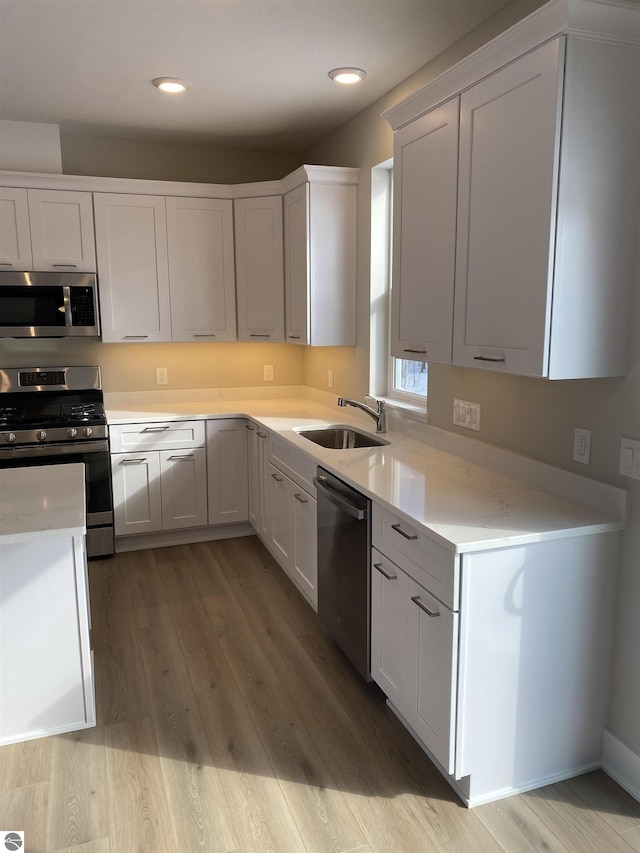 kitchen featuring light hardwood / wood-style floors, sink, white cabinetry, and stainless steel appliances