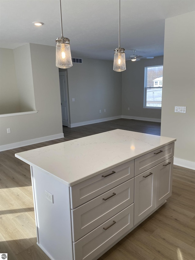 kitchen with a kitchen island, wood-type flooring, and hanging light fixtures