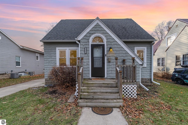 view of front of property with a yard and cooling unit