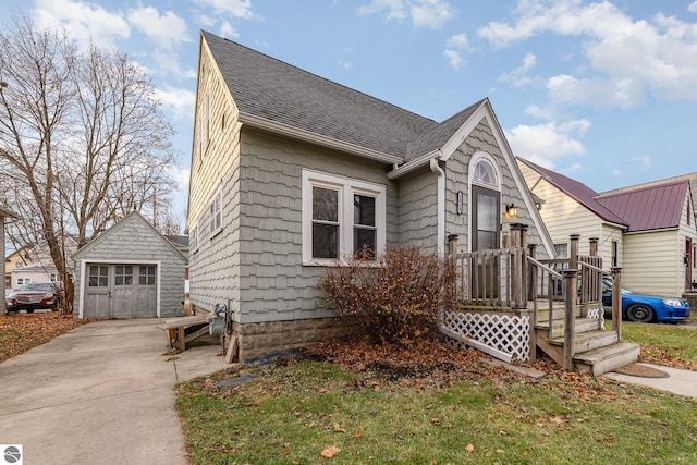 view of front facade with an outbuilding, a garage, and a front yard