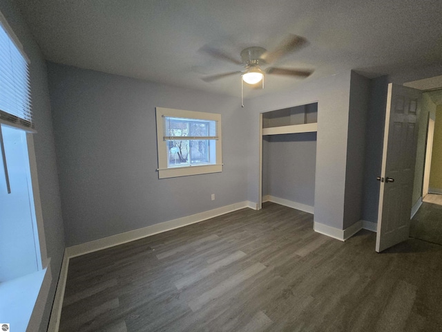 unfurnished bedroom featuring a textured ceiling, ceiling fan, dark wood-type flooring, and a closet