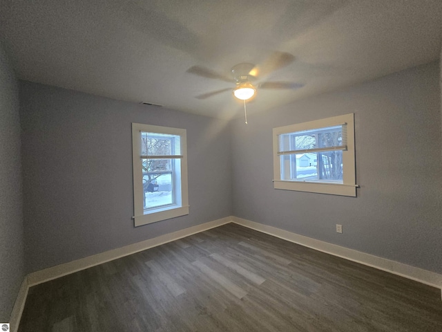 unfurnished room featuring dark hardwood / wood-style floors, ceiling fan, and a textured ceiling