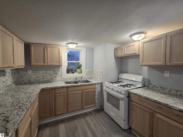 kitchen featuring white gas stove, sink, dark hardwood / wood-style floors, backsplash, and a textured ceiling