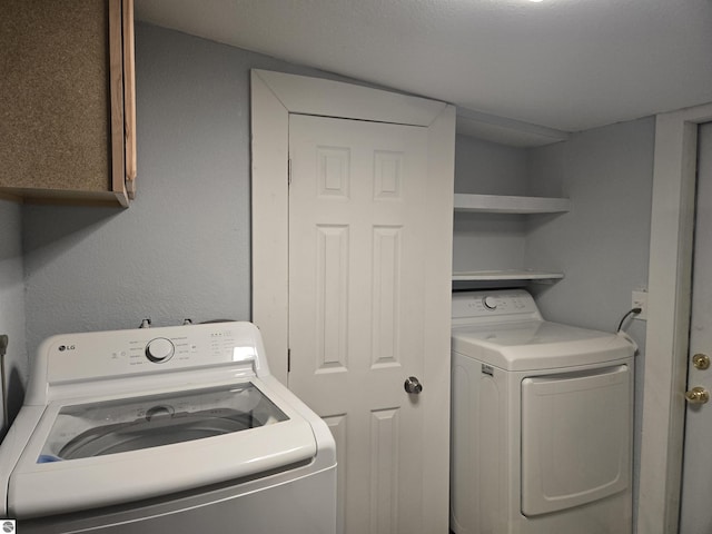 washroom featuring cabinets and independent washer and dryer